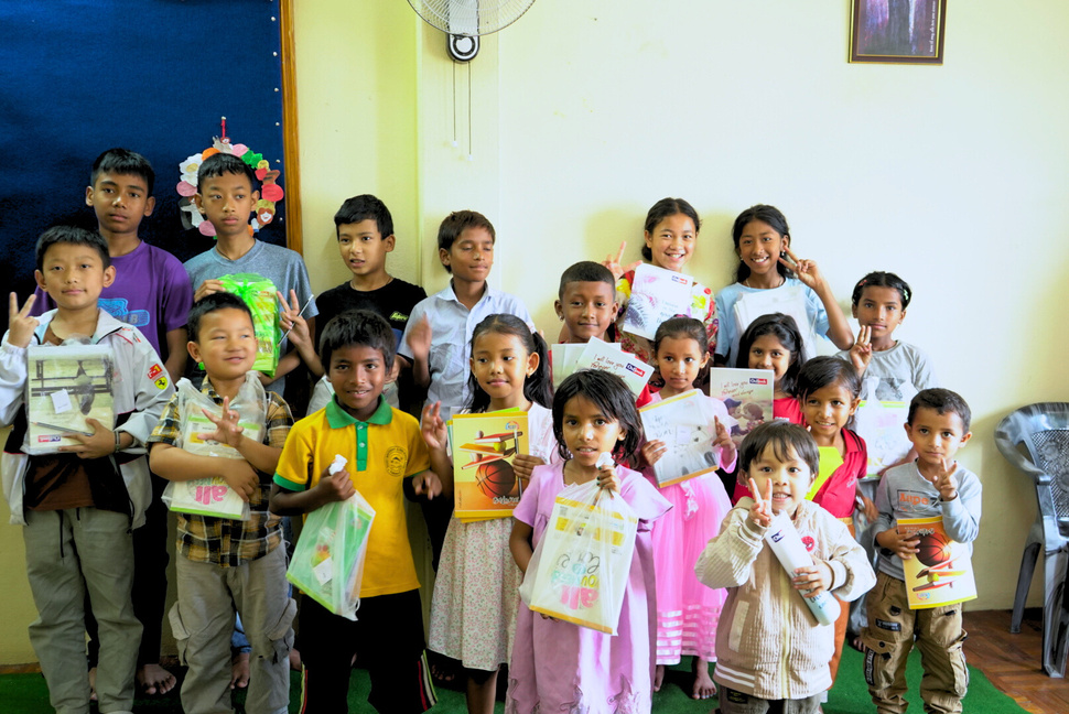 Children holding school supplies provided through community support